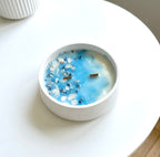 Vela com flores naturais e cristais sodalita